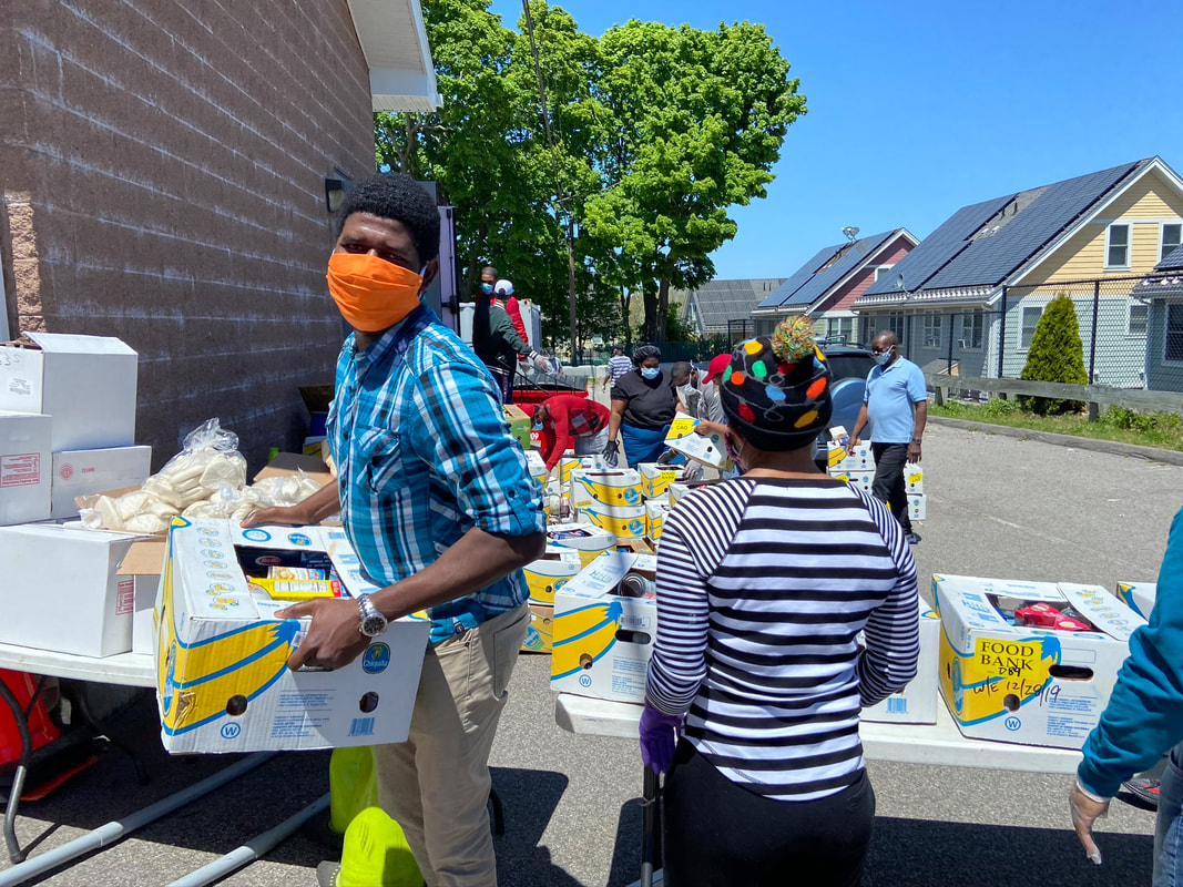 Volunteers wearing their donated fabric face masks distribute food outside a food bank.
