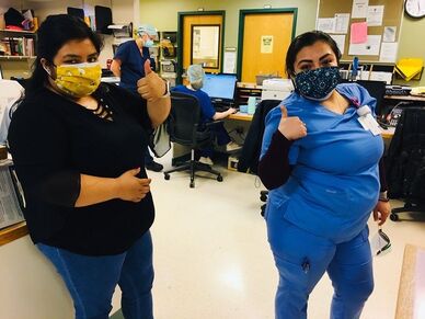 Two healthcare works wear their BAMI face masks and give the thumbs up.